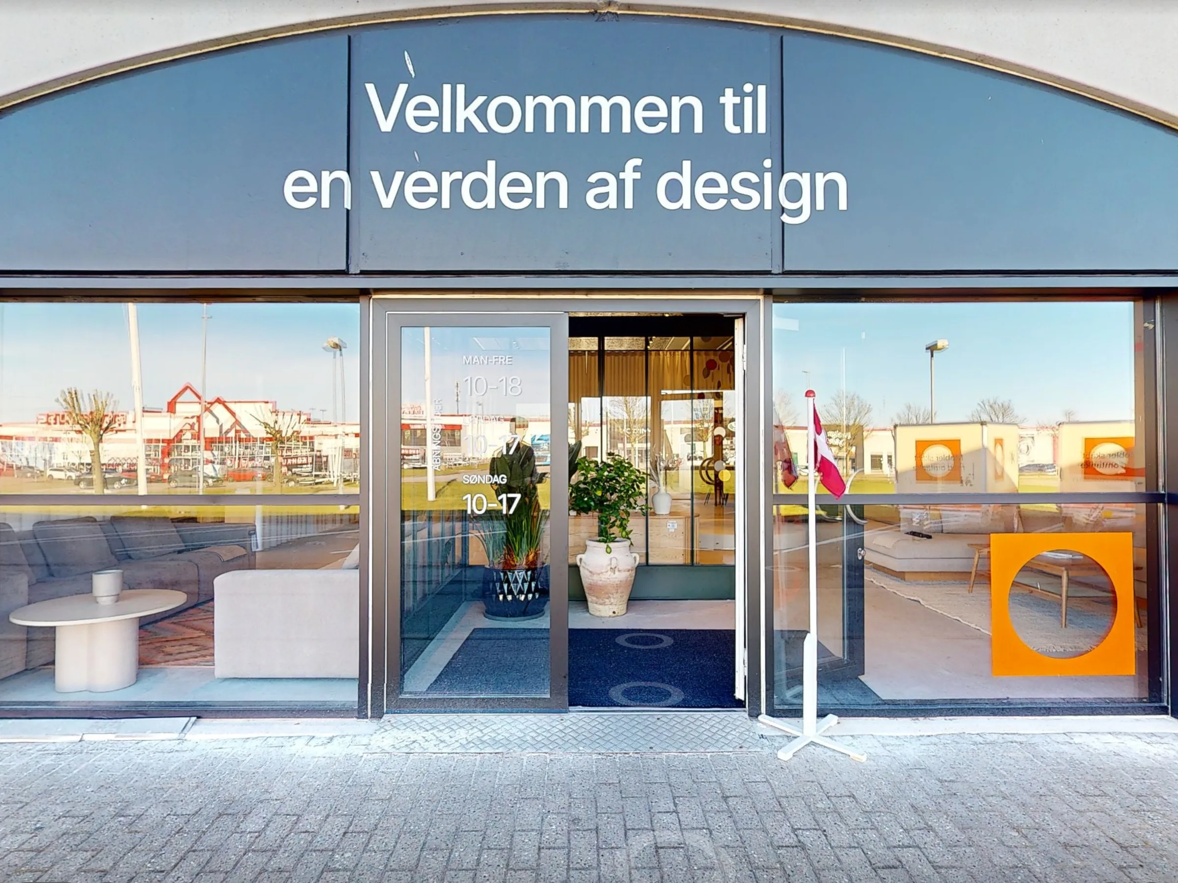 Aalborg-showroomets indgang set udefra med skiltet «Velkommen til en verden af design»
